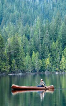 TROLLING BY CANOE: Fly fishing doesn't necessarily mean casting. Some anglers, like Bruce Leach, have good success trolling a fly along still, small lakes.